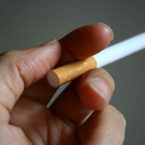 A person holding a cigarette in their hand.