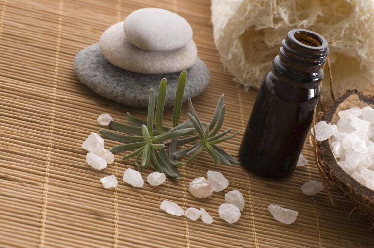 A bottle of essential oil and some rocks on the floor