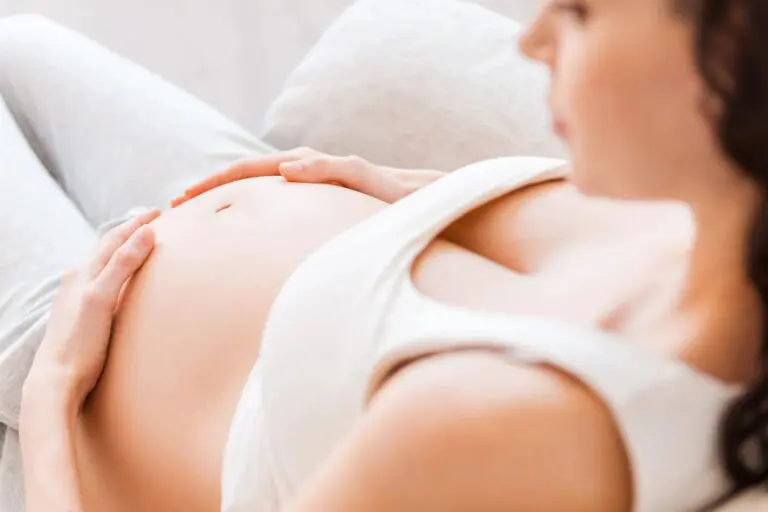 A woman laying on the ground with her stomach up.