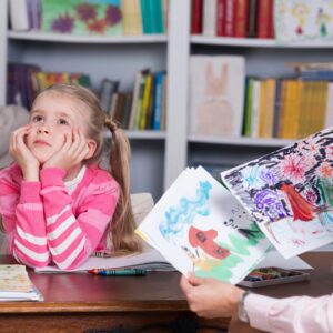 A girl sitting at the table with her mother.