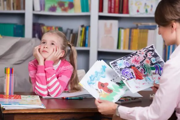 A girl sitting at the table with her mother.