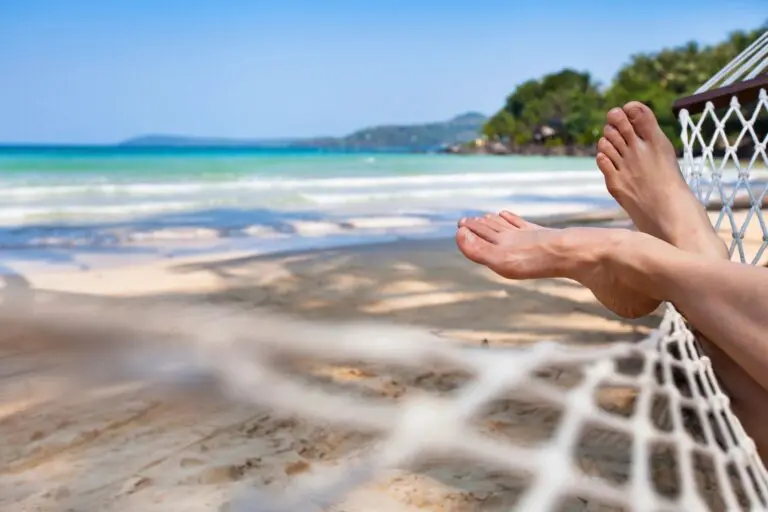 A person laying on the beach with their feet in the air.