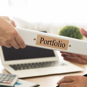 A person is holding onto a folder with the word portfolio on it.