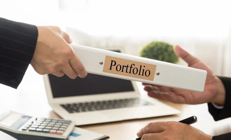 A person is holding onto a folder with the word portfolio on it.