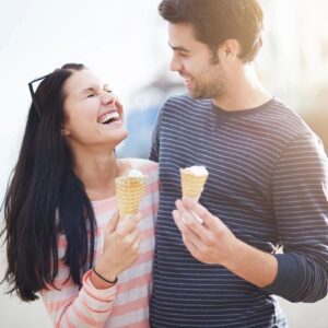 A man and woman holding ice cream cones.