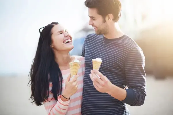 A man and woman holding ice cream cones.