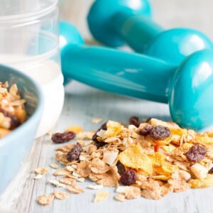 A bowl of cereal and two blue dumbbells.