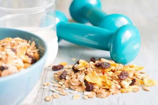 A bowl of cereal and two blue dumbbells.