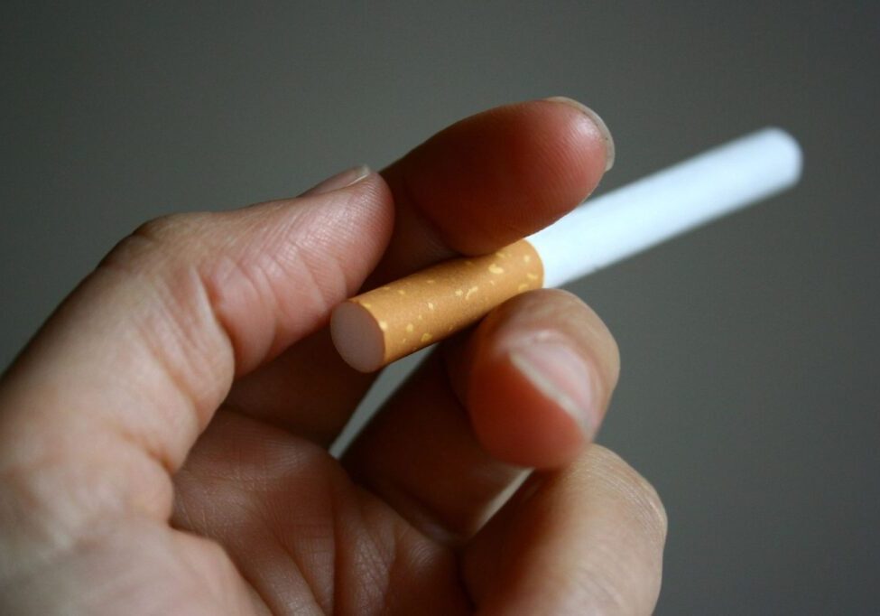 A person holding a cigarette in their hand.