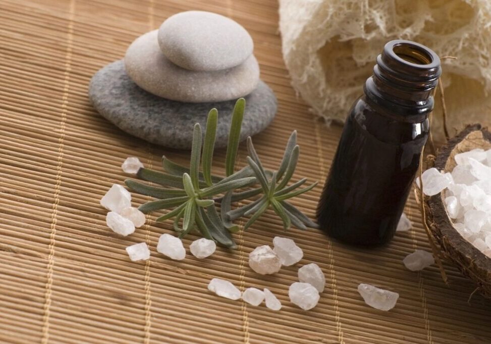 A bottle of essential oil and some rocks on the floor