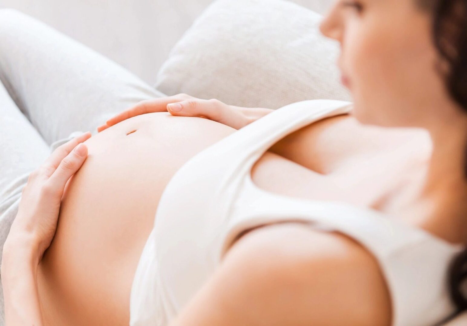 A woman laying on the ground with her stomach up.