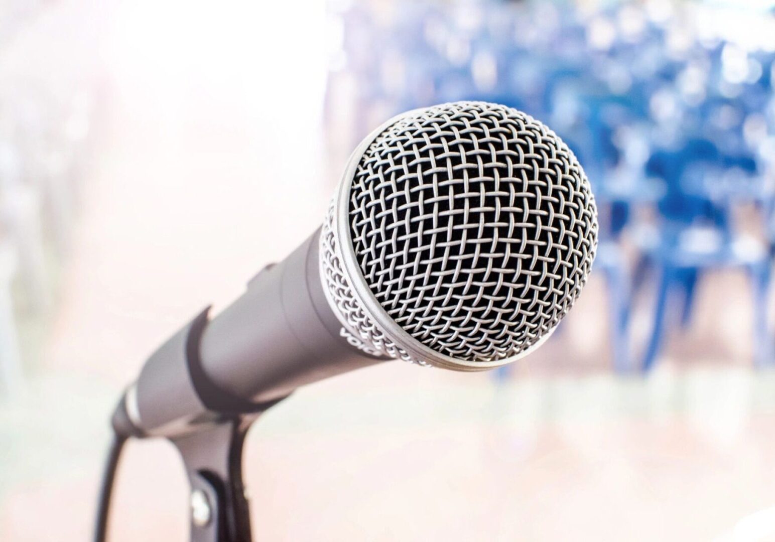 A microphone is on the stand in front of some flowers.