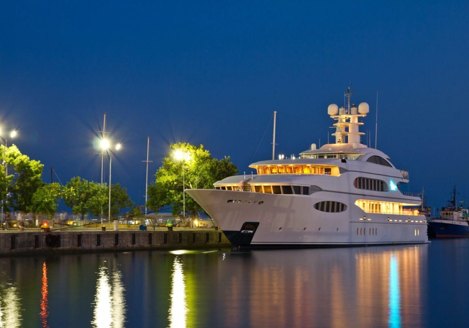 A large white boat docked at the dock.