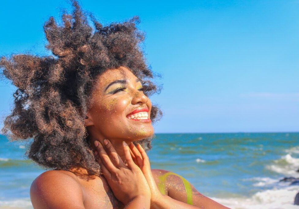 A woman with her hands on her face and smiling.